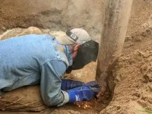 A well technician completes a weld for a well extension during a pump conversion in rural Ottawa.